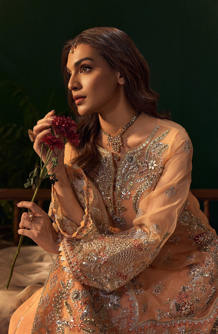 Close-up of Morganite peach evening dress with delicate lace embroidery on the neckline and straps for a luxurious touch